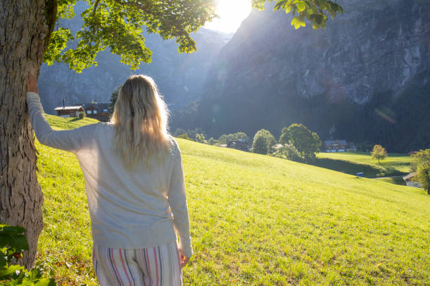 istock Woman relaxes in grassy meadow, under tree 1350018530