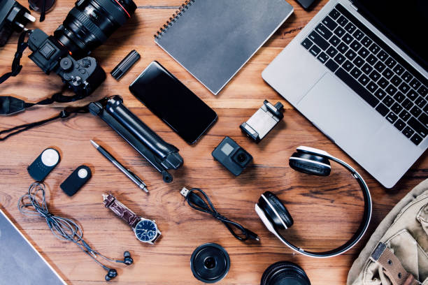 istock digital camera, charger, camera, lens, video camera, USB, personal laptop, book, pen, glasses, remote control, and electronics camera accessory photography concept on wooden background. Top view 1350019784