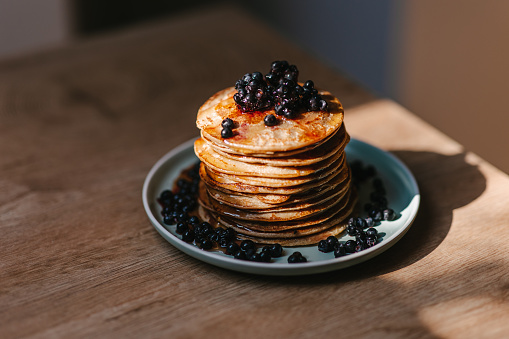 Vegan oatmeal pancakes with wild blueberries on top and maple syrup