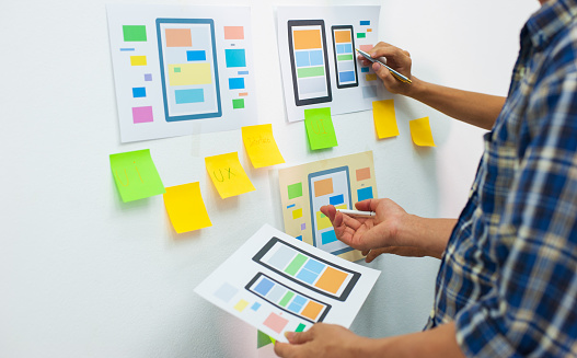 App designers work together to plan user interface layouts for mobile apps.