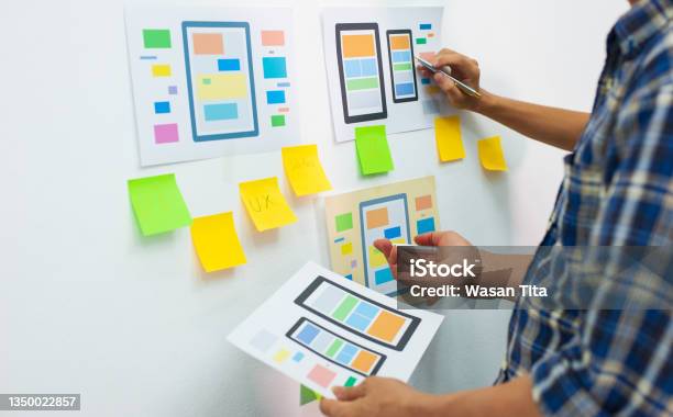 App Designers Work Together To Plan User Interface Layouts For Mobile Apps Stock Photo - Download Image Now