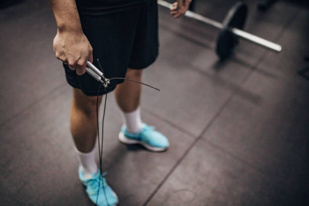 One man, fit man holding jump rope in gym.