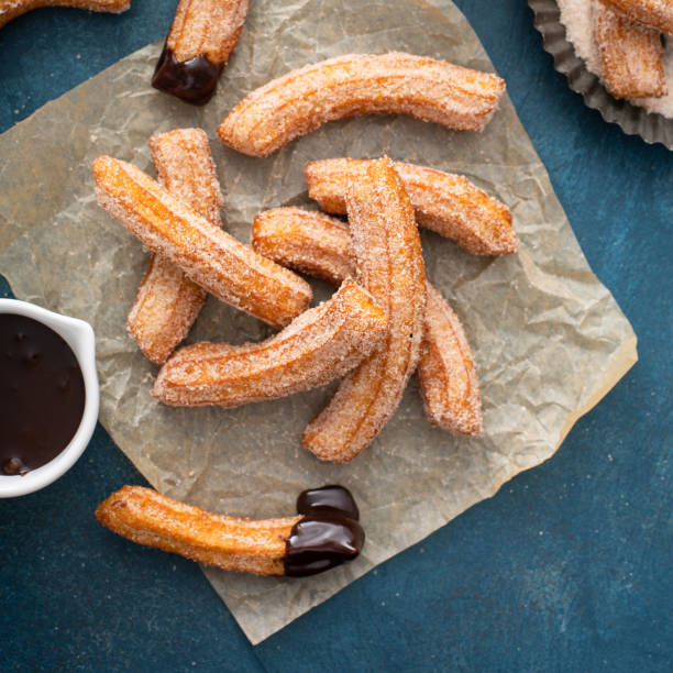Homemade churros with cinnamon sugar on parchment