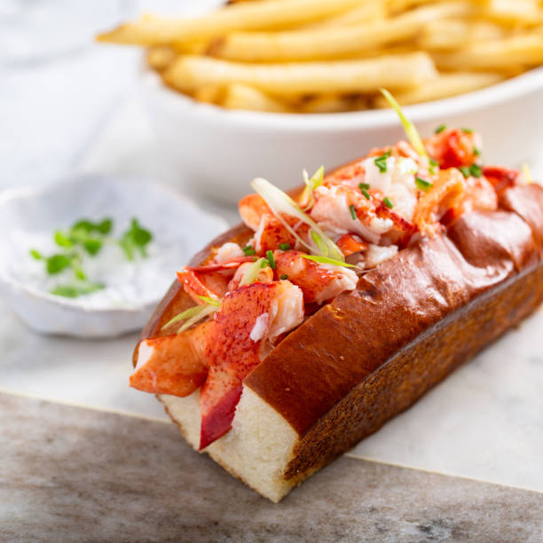 Lobster roll with fries on a marble board
