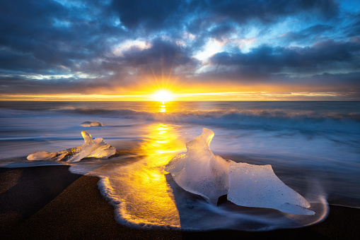 Diamond beach in Vatnajokull, southern Iceland. Sunrise shot of chunks of ice on the black sand, that have been depoited on the beach from the Jokulsarlon glacier lagoon.