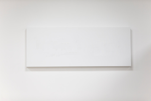 Empty rectangular picture frame on a gray wall.