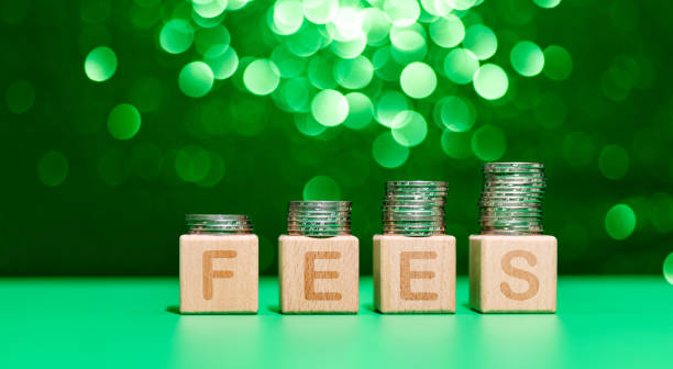 Stack of coins on word fees stock photo