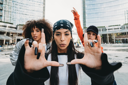 Three female dancer friends are posing in a modern city