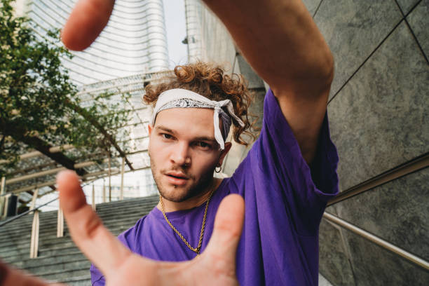 Portrait of a young adult hip man in the city Portrait of a young adult hip man in the city. He's standing on a staircase, looking at camera. Alternative urban dressing. bandana photos stock pictures, royalty-free photos & images