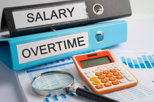 Salary, Overtime. Binder data finance report business with graph analysis in office. stock photo