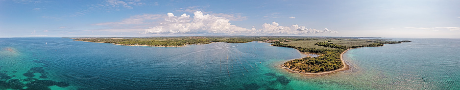 Drone panorama over the Istrian Adriatic coast near Porec with Porto Busola peninsula during the day in summer