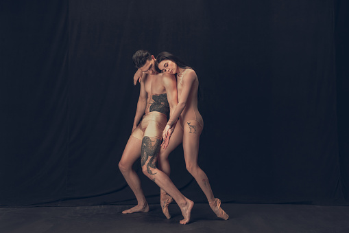 Despair. Two flexible dancer, young man and woman in modern art performance isolated on black background. Art, motion, action, flexibility, inspiration concept. Flexible artist. Beauty of human body