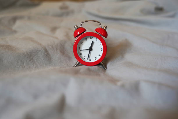istock Red Alarm clock on the bed at home 1350030577