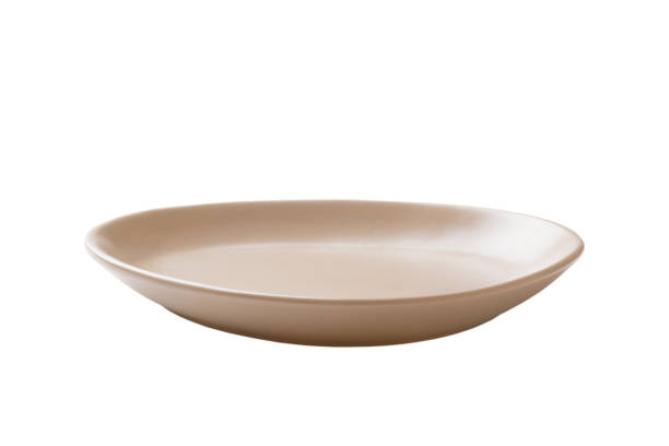 istock milky color ceramic round plate isolated over white background. perspective view 1350032251