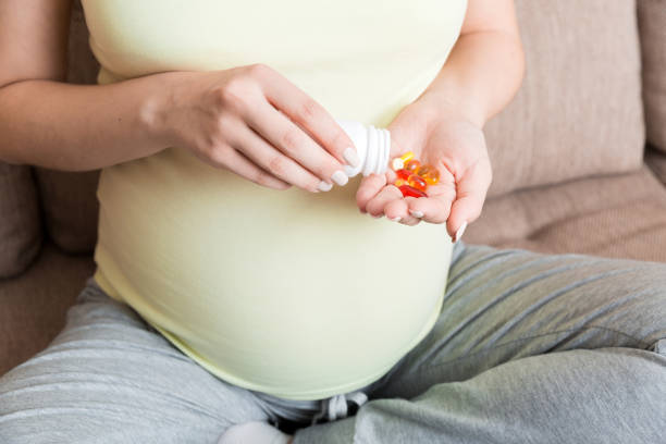 pilules de prise de main de femme pour améliorer le taux de fer dans le sang. recevoir des vitamines pendant la grossesse, concept de soins de santé millénaires en bonne santé - sante fe home photos et images de collection