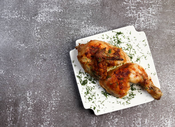 istock Roasted chicken on a square plate on a dark background 1350033655