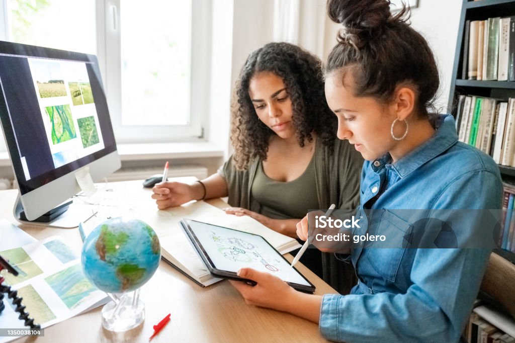 two young woman working together on concepts for climate protection two young woman preparing together concepts for climate protection on desk indoors Sustainable Lifestyle Stock Photo