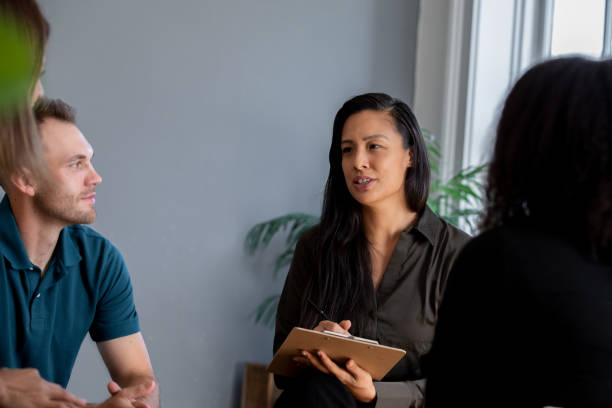 istock Woman writing on clipboard in group meeting 1350041623