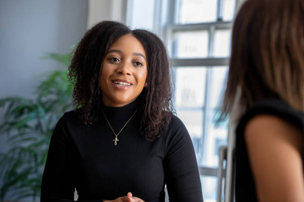 Millennial Woman talking to university advisor stock photo