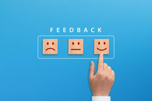 Customer satisfaction or feedback concept, hand choosing smiley emoticon on wooden blocks