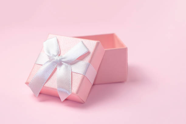 istock Pink gift box with a white bow. Open gift box on pink background 1350051695
