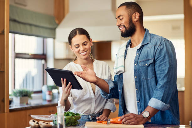 istock Shot of a young couple using a digital tablet while cooking at home 1350051805