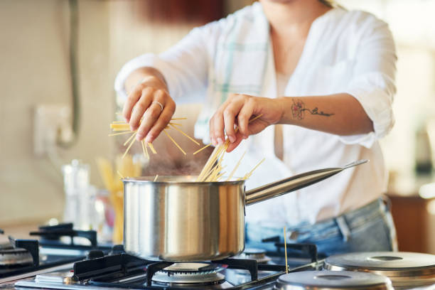istock Shot of a woman breaking spaghetti before boiling it 1350051817