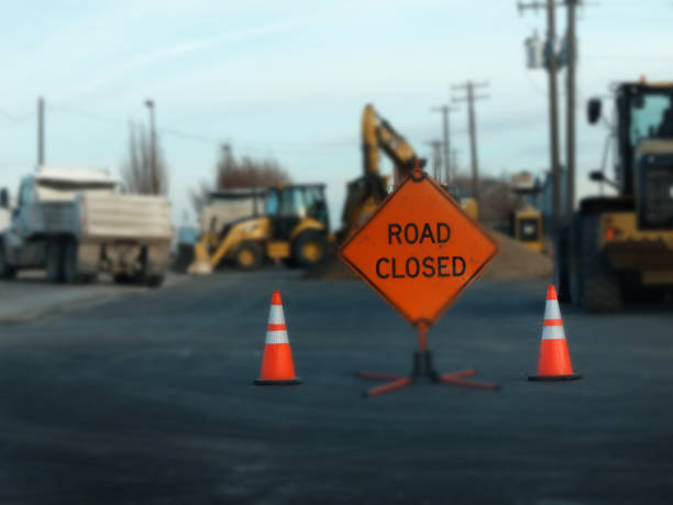 istock Road closed sign for work construction heavy equipment 1350051972