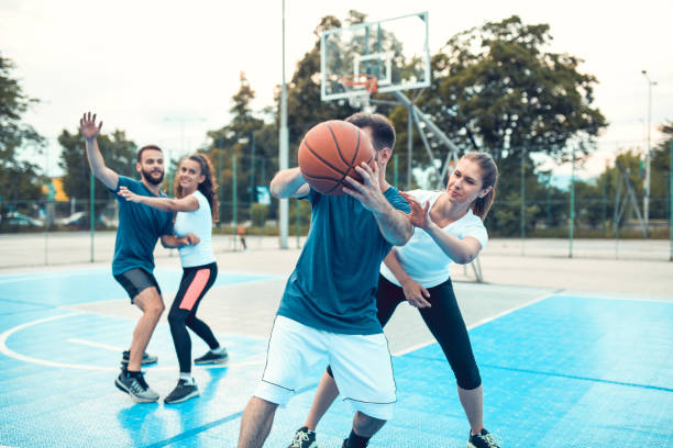 istock Competitive Couples Enjoying Basketball Match On Court 1350052731