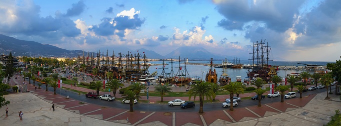 Alanya, Turkey, September 10, 2021: Panoramic view of the harbor and the coastline of Alanya illuminated partly by setting sun.