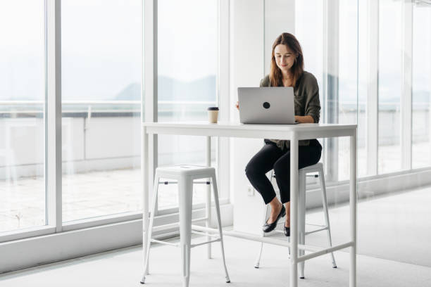 istock Promising young woman working on her laptop 1350060969