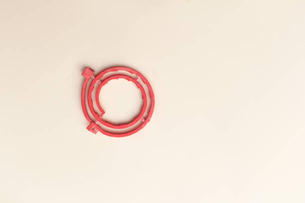 new red collar for fleas and ticks lies on a pink background