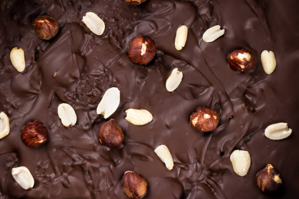 istock chocolate background with peanuts and hazelnuts close-up, top view 1350065297