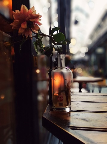 Glass bottle with a candle and flower in autumn colours