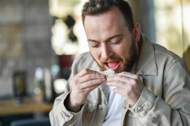 istock Handsome Male Eating Breakfast Toast In Restaurant 1350067975
