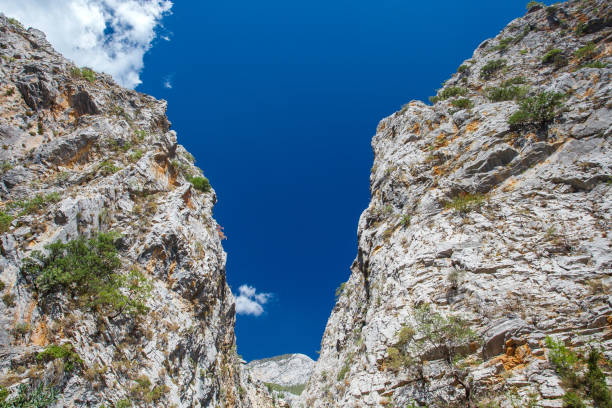 Gorge, overhanging rocks and rocks in mountainous area, during  day.