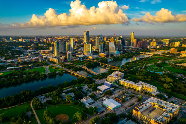 High View across entire Austin Texas Skyline at Snuset Aerial drone views over Austin Texas Golden Hour Sunset in the Capital City of TX with tall skyscrapers and modern buildings along the Colorado River with bridges and green landscape surrounding Texas Hill Country golden hour photos stock pictures, royalty-free photos & images