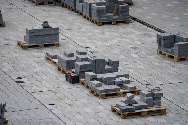 Process of construction of gray brick paved sidewalk, half built pavement road. High quality photo