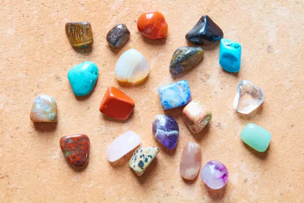Any colorful semi-precious stones lie next to each other.