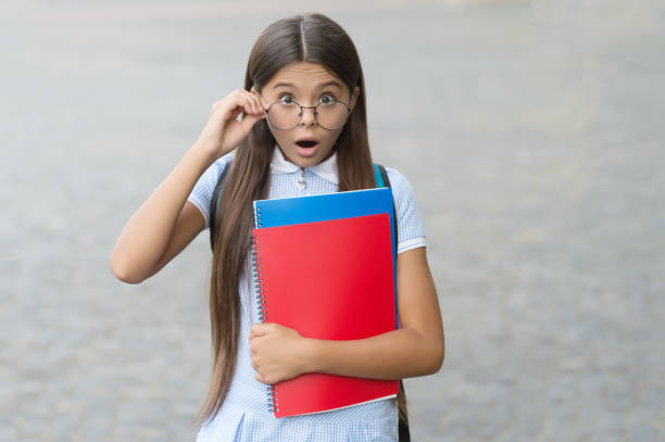 Wow. Surprised child look through glasses outdoors. Sight test. Eye check for school. Vision screening. Protecting eye sight. Pediatric ophthalmology. Primary education