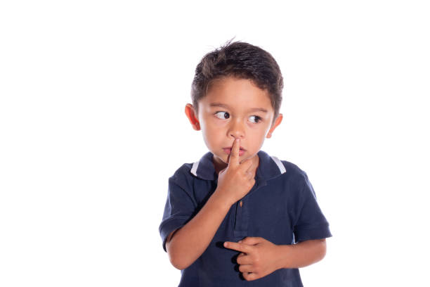 istock Child asking for silence, isolated on white background. Latin boy asks for silence with finger on mouth. 1350076388