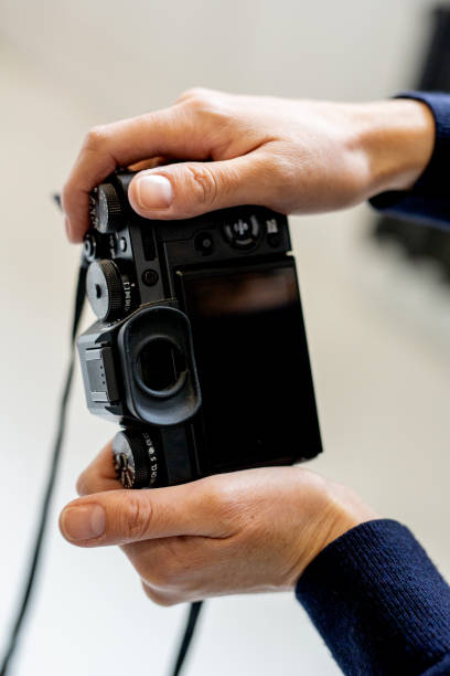 istock Women's hands are holding a close-up camera in their hands. concept is a working tool in the hands of a journalist 1350076419
