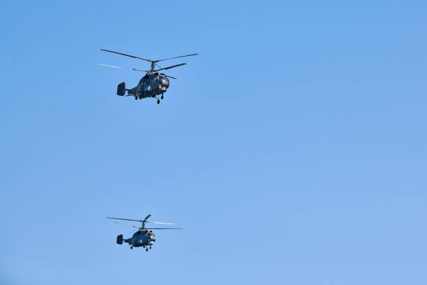 dwa wojskowe śmigłowce latające po błękitnym niebie wykonujące lot pokazowy, pokaz lotniczy - fighter plane aerospace industry air air vehicle zdjęcia i obrazy z banku zdjęć