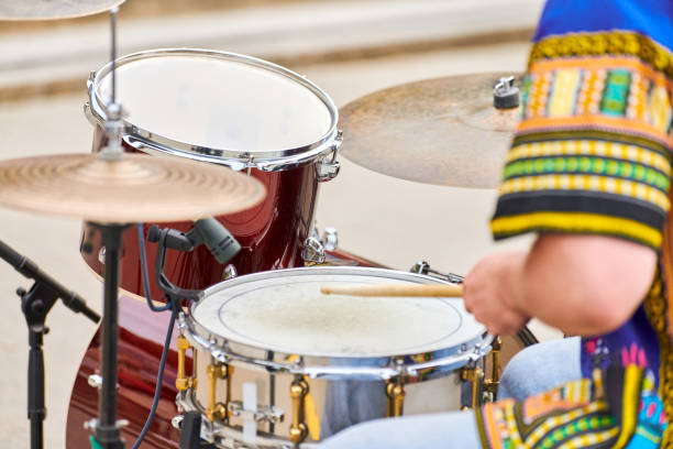 istock Drummer man playing drums percussion with drum sticks, drum set on concert stage, sticks and drums 1350080258