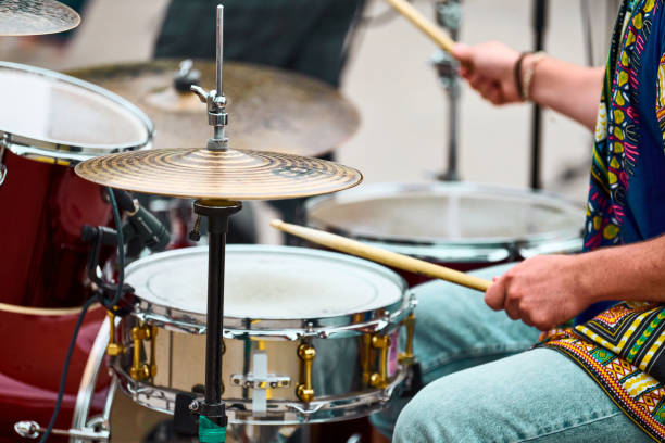 istock Drummer man playing drums percussion with drum sticks, drum set on concert stage, sticks and drums 1350080267