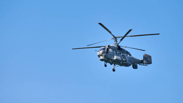 istock Navy helicopter flying against blue sky background, copy space. One rotary wing aircraft, side view 1350080282