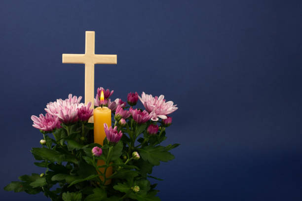 Composition of burning candle, flowers and wooden cross for all souls day. Also suitable for funeral, mourning, grief. Composition of burning candle, flowers and wooden cross for all souls day. Also suitable for funeral, mourning, grief. Copy space. pink memorial candle with flowers stock pictures, royalty-free photos & images