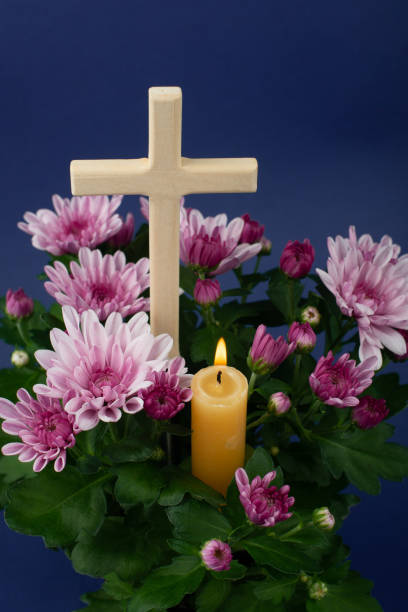 Composition of burning candle, flowers and wooden cross for all souls day. Also suitable for funeral, mourning, grief. Composition of burning candle, flowers and wooden cross for all souls day. Also suitable for funeral, mourning, grief. High angle view. pink memorial candle with flowers stock pictures, royalty-free photos & images
