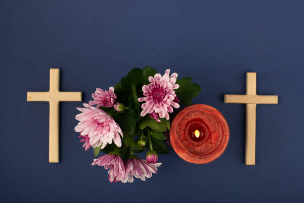 Composition of burning candle, flowers and wooden cross for all souls day. Also suitable for funeral, mourning, grief. Composition of burning candle, flowers and wooden cross for all souls day. Also suitable for funeral, mourning, grief. Table top view. pink memorial candle with flowers stock pictures, royalty-free photos & images