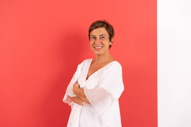 Portrait of mature woman against colored wall. stock photo
